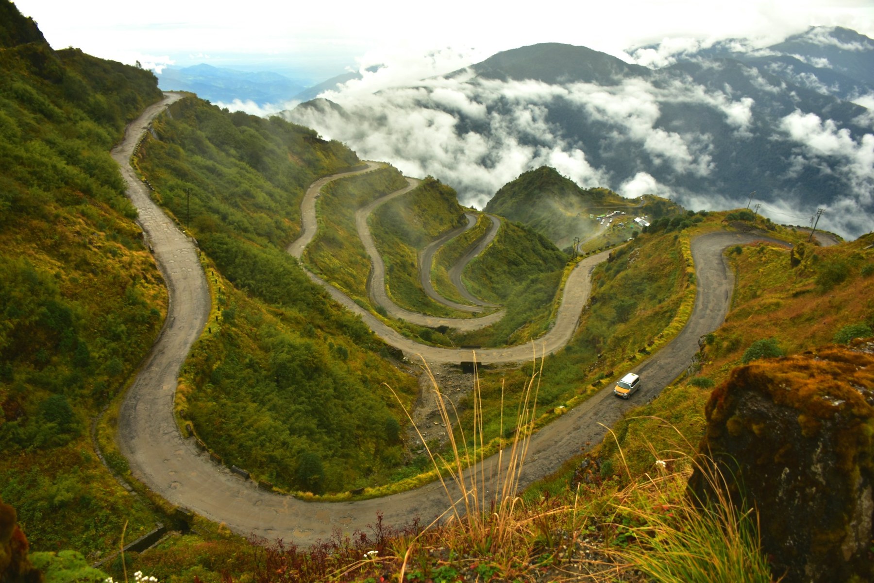 Winding mountain road through lush green hills in Sikkim